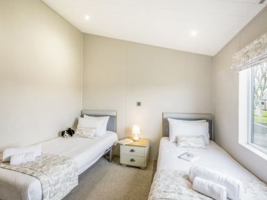A bedroom with two single beds and a bedside table at Lodge 55 at Riviera Bay Coastal Retreat Brixham