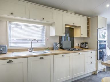 A kitchen with appliances and cabinetry at Lodge 58 at Riviera Bay Coastal Retreat Brixham