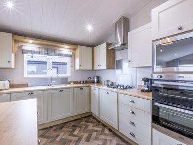 A kitchen with appliances and a window at Lodge 62 at Riviera Bay Coastal Retreat in Brixham