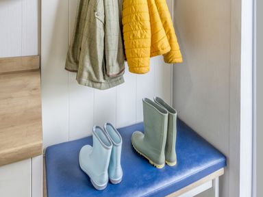 An entryway with a yellow and green coat and blue and green boots at Lodge 63 at Riviera Bay Coastal Retreat Brixham