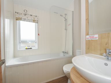 A bathroom with a bathtub shower combination sink and toilet at Lodge 70 at Riviera Bay Coastal Retreat in Brixham