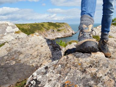 A person standing on rocks near the coast at Lodge 70 at Riviera Bay Coastal Retreat Brixham