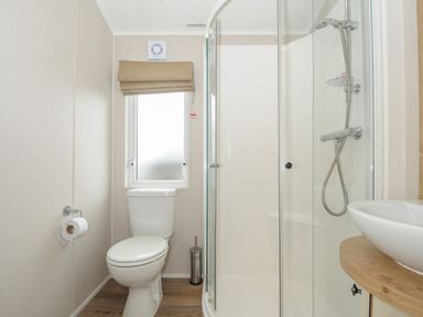 A bathroom with a toilet window shower and sink at Lodge 64 at Riviera Bay Coastal Retreat in Brixham