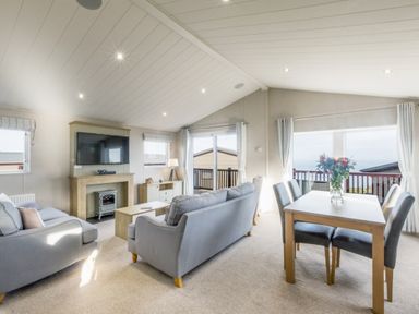 A living room with sofa, table, and television at Lodge 64 at Riviera Bay Coastal Retreat Brixham