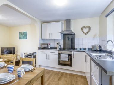 A kitchen with appliances and dining area at Chalet 31 at Landscove Holiday Park, Brixham
