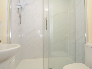 A bathroom with a shower enclosure a sink and a toilet at Chalet 33 at Landscove Holiday Park in Brixham