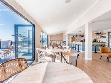 A restaurant with tables and a bar at Chalet 33 at Landscove Holiday Park Brixham