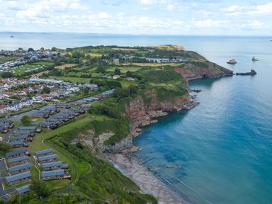 An aerial view of a coastal area with a holiday park and ocean at Chalet 34 at Landscove Holiday Park Brixham