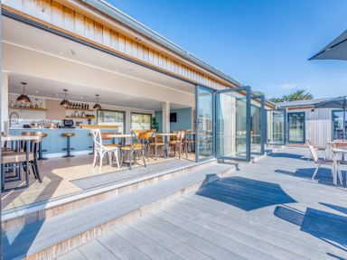 An outdoor seating area with tables and chairs at Chalet 34 at Landscove Holiday Park Brixham
