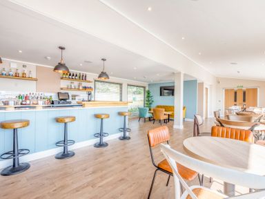 A bar area with stools and tables at Chalet 34 at Landscove Holiday Park in Brixham