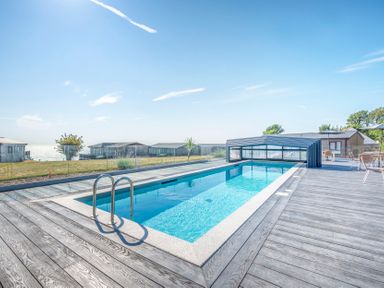 An outdoor area with a swimming pool and bungalows at Chalet 38 at Landscove Holiday Park Brixham