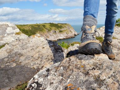 A person standing on rocks near the water at Lodge 9 at Landscove Holiday Park Brixham