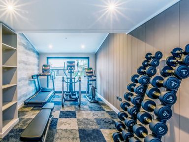 A gym with exercise equipment and dumbbells at Lodge 9 at Landscove Holiday Park Brixham