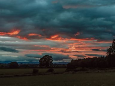 A landscape with trees and clouds during sunset at La'al Ling in Penrith