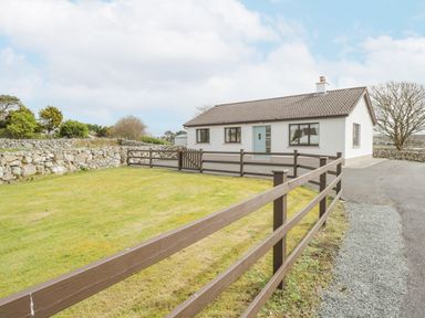 A single-story house with a lawn and brown wooden fence at Rossaveel Upper in Rossaveel County Galway