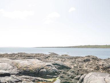 A rocky coastline with ocean water and distant land at Rossaveel Upper in Rossaveel County Galway