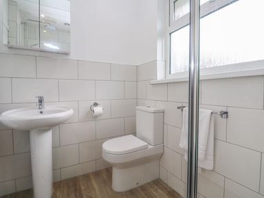 A bathroom with a pedestal sink toilet towel rack and frosted window at Bod A Quinte in Carbis Bay