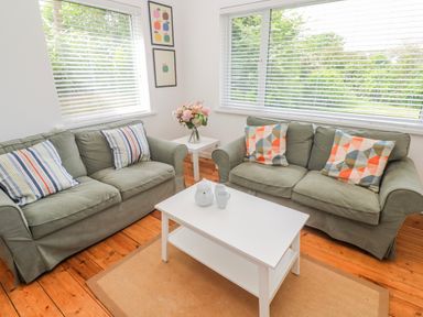 A living room with sofas, a coffee table and a vase of flowers at Bod A Quinte, Carbis Bay