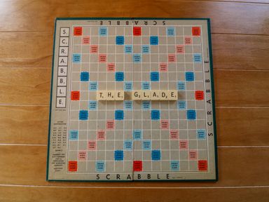 A Scrabble board with the word THE GLADE spelled out on wooden tiles on a wooden floor at 3 The Glade in St Minver Rock