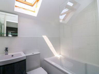 A bathroom with a toilet sink bathtub and skylight at Splash in Weymouth