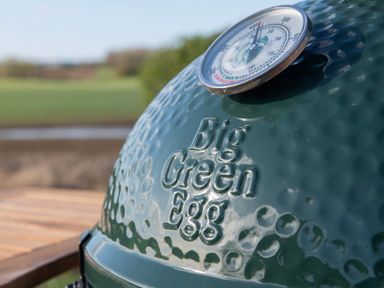 A close-up of a green Big Green Egg grill with a temperature gauge in an outdoor setting at Glamping Pod 2 Presence Lebberston
