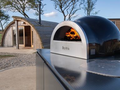 A wood-fired pizza oven outside a wooden glamping pod at Glamping Pod 2 Presence in Lebberston