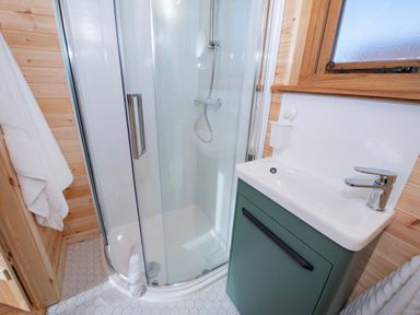 A bathroom with a glass shower enclosure sink with cabinet and a window at Glamping Pod 3 Harmony in Lebberston