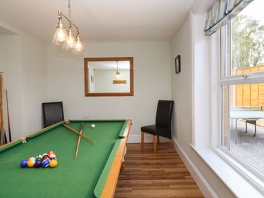 A game room with a pool table two chairs a window and a mirror at Metcalfe House in Compton Dundon