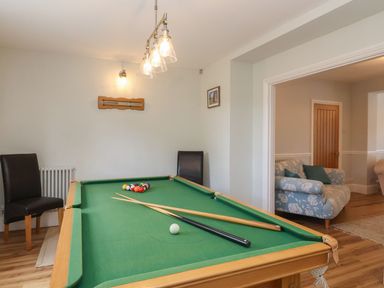 A room with a pool table and two chairs next to it at Metcalfe House in Compton Dundon
