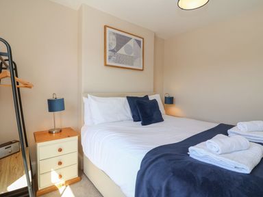 A bedroom with a double bed bedside tables and folded towels at Metcalfe House in Compton Dundon