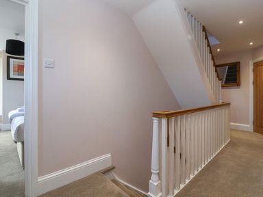 A hallway with stairs and a wooden door at Metcalfe House in Compton Dundon