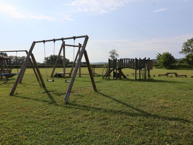 A playground with swings and a play structure at Metcalfe House in Compton Dundon