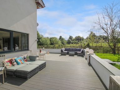 An outdoor patio area with two seating arrangements and a small round table at Timberdyne in Brimfield near Woofferton