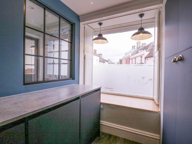 A room with dark cabinetry a countertop a window opening to a street view and two pendant lights at Number 1 in Clare