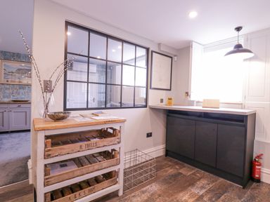 A room with a wooden crate shelf and black cabinets under a window at Number 1 in Clare