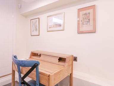 A wooden desk with a blue chair and three framed pictures on the wall in a small workspace at Number 1 in Clare