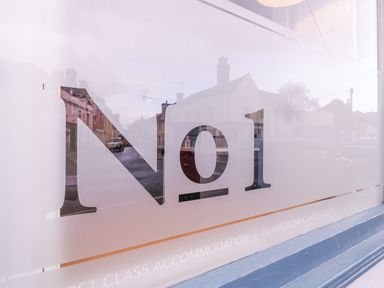 Frosted glass window with number 1 and street reflection at Number 1 in Clare