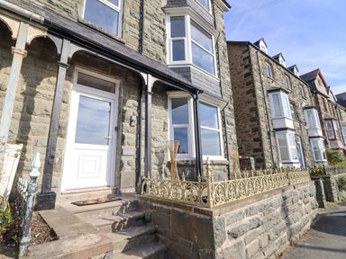 Stone terrace houses with iron railings and bay windows at Gwynfa in Barmouth