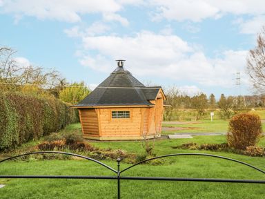A wooden cabin viewed from a garden at 1 Gilpin House Levens