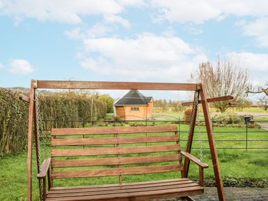 A swing in a garden with a shed in the background at 1 Gilpin House Levens