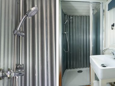 A shower area with a handheld showerhead and corrugated metal walls next to a white sink in a bathroom at Collen in Aberaeron