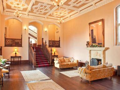 A sitting room with sofas fireplace and staircase at The Hall in Belford