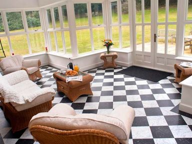 A sunroom with wicker furniture and checkered floor at The Hall in Belford