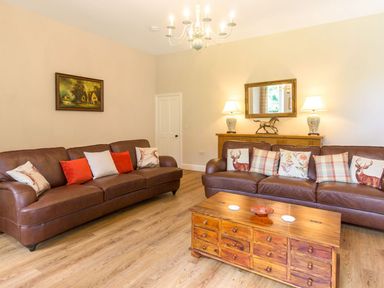 A living room with two brown leather sofas and a wooden coffee table at The Coach House in Belford