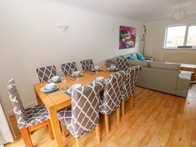 A dining room with a table and chairs at 15 Lawnswood in Saundersfoot