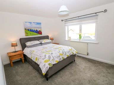 A bedroom with a bed and bedside tables at 15 Lawnswood in Saundersfoot
