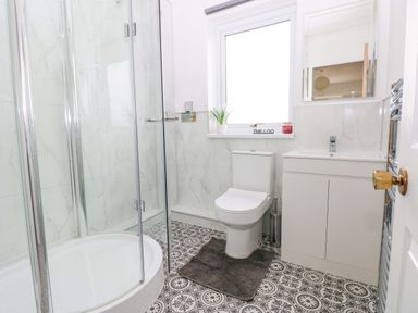 A bathroom with a shower, toilet, and sink at 15 Lawnswood in Saundersfoot