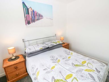 A bedroom with a bed, bedside tables and lamps at 15 Lawnswood in Saundersfoot