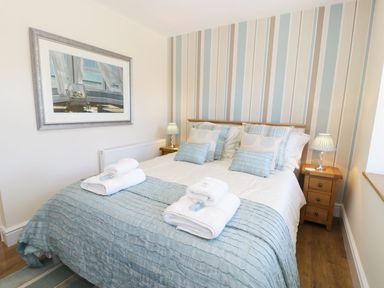 A bedroom with a double bed pillows and folded towels on the bed at Old Post Office in Blaenau Ffestiniog
