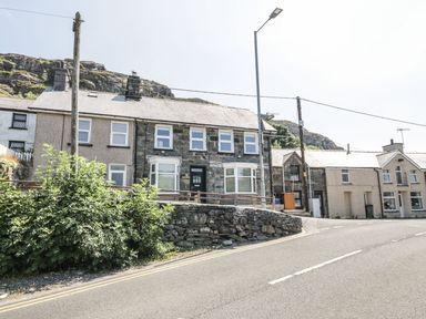 A street with stone and brick houses hills in the background at Old Post Office in Blaenau Ffestiniog